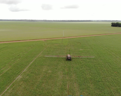 tracteur en train de pulvériser un produit phytosanitaire dans un chams